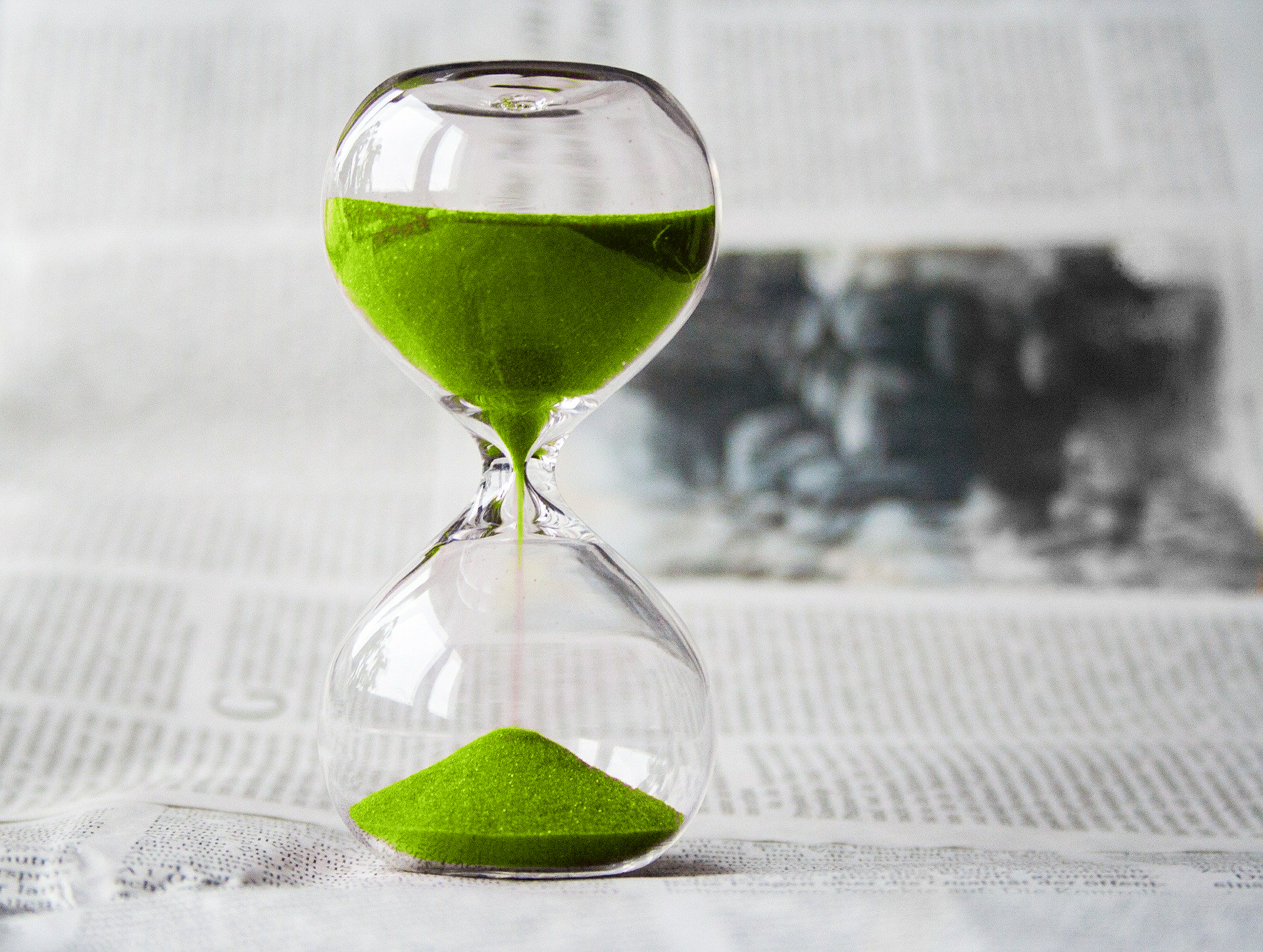 imagen de reloj de arena sobre páginas de diario